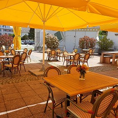 Restaurant Terrasse bestuhlt mit gelben Sonnenschirmen