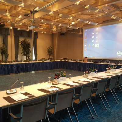 Kleiner Saal in U-Form mit Leinwand und beleuchtet